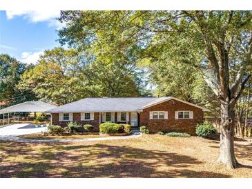 Brick ranch house with attached carport, landscaping, and a spacious yard at 2639 Odum St, Snellville, GA 30078