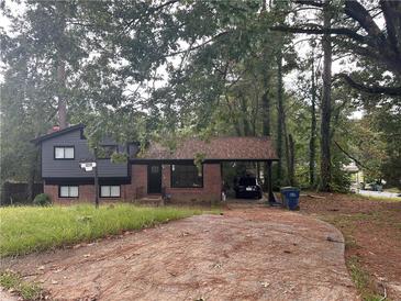 Brick ranch house with a carport and mature trees at 3230 Vanderbilt Nw Ln, Atlanta, GA 30318