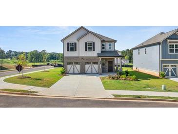 Two-story house with a three-car garage and landscaping at 1861 Holmsey Cir, Conyers, GA 30094