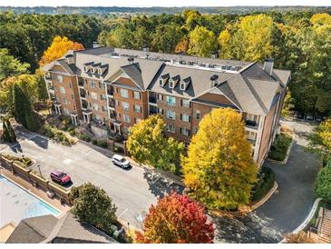 Aerial view of a brick apartment building with fall foliage and a pool at 2300 Peachford Rd # 1209, Atlanta, GA 30338