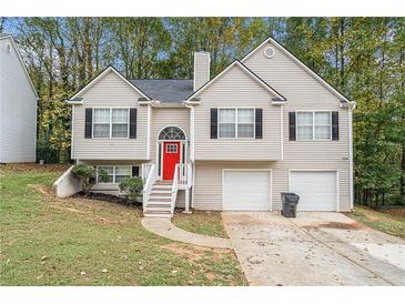 Two-story house with a red door, two-car garage, and landscaped yard at 6943 Fairway Trl, Austell, GA 30168
