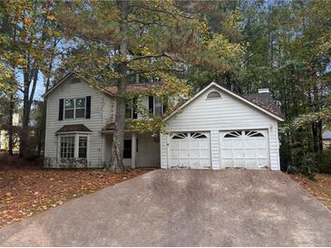 Two-story house with double garage and tree-lined yard at 310 Wolf Downs Way, Atlanta, GA 30349