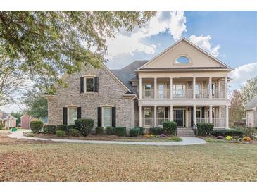 Two-story brick home with a front porch and landscaped yard at 4348 Meadow Vista Dr, Stonecrest, GA 30038