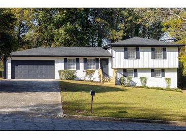 Charming ranch home with gray garage door and white exterior at 7543 Palmetto Way, Riverdale, GA 30274