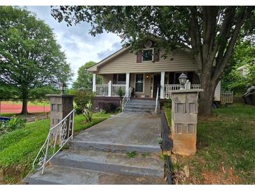 Charming two-story home with a covered front porch, concrete walkway, and brick columns at 212 Little St, Atlanta, GA 30315