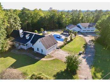 Aerial view of house, pool, and detached garage; large lot with mature trees at 8948 Ephesus Church Rd, Villa Rica, GA 30180