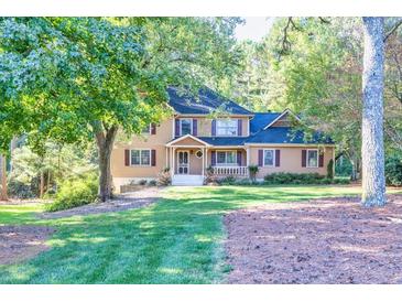 Two-story house with a wraparound porch, situated on a grassy lot at 5892 Smoke Rise Ct, Stone Mountain, GA 30087