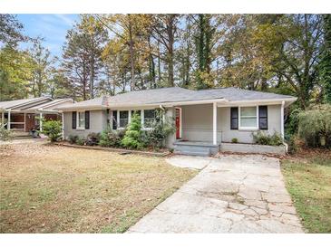 Charming ranch home with gray brick exterior, red door and landscaped yard at 2435 Wood Valley Dr, Atlanta, GA 30344