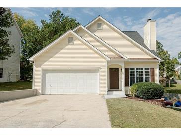 Charming yellow house with a two car garage and manicured lawn at 218 Toulouse St, Dallas, GA 30157