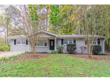 Brick ranch home with a landscaped yard and driveway at 7047 Carolyn Cir, Lithia Springs, GA 30122