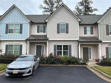 Modern three-unit townhome building with a light gray and light blue exterior at 7762 Fawn Cir, Covington, GA 30014