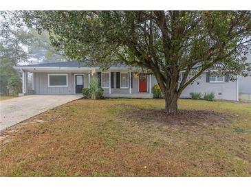 Newly renovated ranch home with gray exterior, red door and mature landscaping at 3905 Cheoah Dr, Douglasville, GA 30135