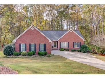 Brick ranch house with a landscaped lawn and driveway at 868 Clarion Way, Lawrenceville, GA 30044