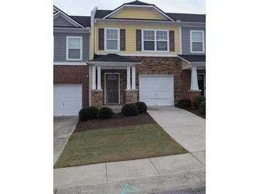 Two-story townhouse with two-car garage and stone accents at 832 Arbor Gate Ln # 832, Lawrenceville, GA 30044