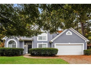 Gray two-story house with a white two-car garage and manicured lawn at 949 Heartwood Cir, Lawrenceville, GA 30043