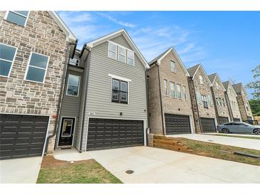 Modern townhouses with stone and gray siding, featuring attached garages at 1525 Burberry Alley, Marietta, GA 30008