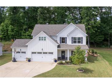 Two story home with white siding, three car garage and landscaped yard at 197 Stafford Ln, Villa Rica, GA 30180