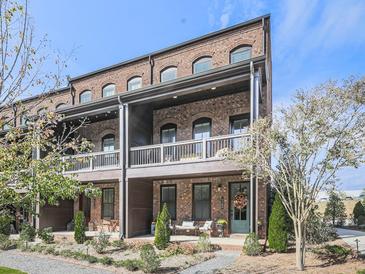 Brick front of charming townhome with front porch and landscaping at 6380 Cortland Walk, Alpharetta, GA 30005