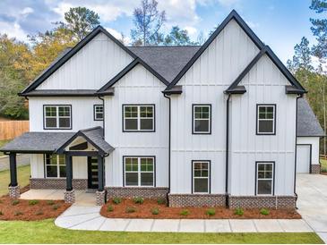 Two-story farmhouse with white siding, black accents, and a brick base at 1387 Mineral Springs Rd, Hoschton, GA 30548