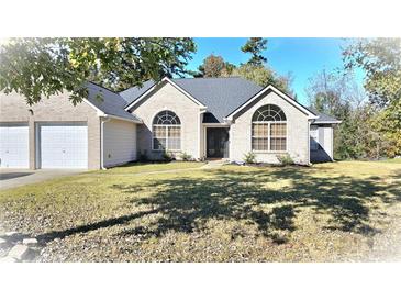 Brick house with a two-car garage and landscaping at 6687 Hill Creek Cv, Lithonia, GA 30058