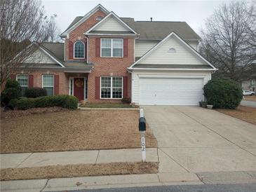 Brick two-story house with a large driveway and landscaped lawn at 102 Ozark Trl, Canton, GA 30114