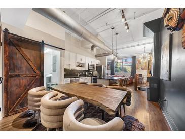 Open concept dining area with a large wooden table and modern chairs at 172 Haynes Sw St # 108, Atlanta, GA 30313