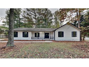 Newly renovated home features white siding, black window trim, and a landscaped yard at 245 Southmoor Cir, Stockbridge, GA 30281