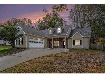 House exterior at dusk featuring a two-car garage and stone accents at 114 Arborwood Way, Temple, GA 30179