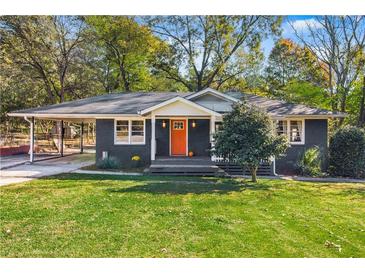 Charming ranch home with a bright orange door and well-manicured lawn at 1138 Bouldercrest Se Dr, Atlanta, GA 30316