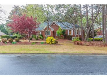 Brick home with landscaped yard and mature trees at 1510 Natchez Way, Grayson, GA 30017