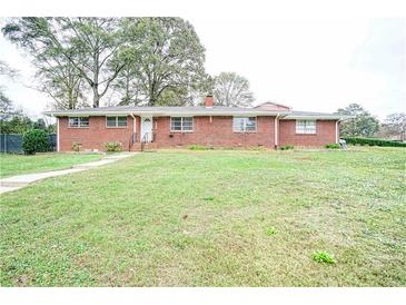 Brick ranch house with a spacious lawn at 680 Sherwood Dr, Jonesboro, GA 30236