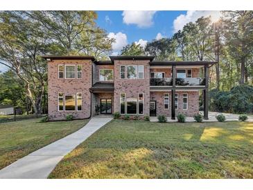 Brick two-story home with walkway, landscaping, and a spacious lawn at 3814 Panola Rd, Lithonia, GA 30038