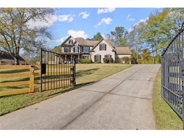 Two-story house with driveway and gated entrance at 7210 Wallace Tatum Rd, Cumming, GA 30028