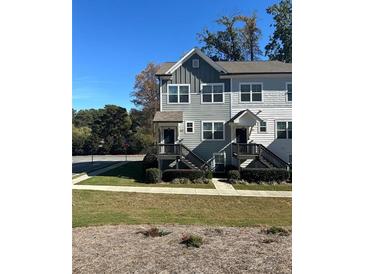 Two-story townhome with gray siding, front porch, and stairs at 3829 Oxford Cir, Doraville, GA 30340