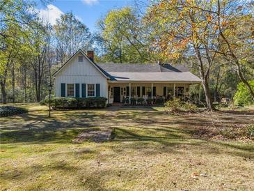 Charming one-story home with white siding, green shutters, and a front porch at 1765 Holly Springs Ne Rd, Marietta, GA 30062