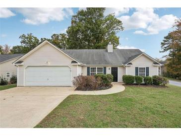 Ranch style house with a two-car garage and well-manicured lawn at 102 Rocky Branch Way, Villa Rica, GA 30180