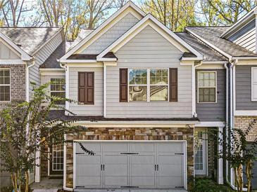 Two-story townhome boasts stone accents and a two-car garage at 4057 Princeton Lakes Sw Way, Atlanta, GA 30331