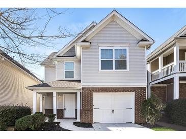 Charming two-story home with a brick and siding exterior, attached garage, and inviting front porch at 611 Shadow Valley Ct, Lithonia, GA 30058