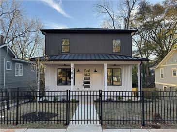 Modern two-story home with a white and dark gray exterior, black fence, and walkway at 1101 Boulevard Se Dr # A, Atlanta, GA 30317