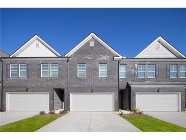 Three-unit townhome building with gray brick exterior and attached garages at 224 Epping St # 7, Stockbridge, GA 30281