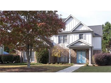 Two-story house with brick and siding, featuring a light blue door and landscaped yard at 340 Bay Grove Rd, Loganville, GA 30052