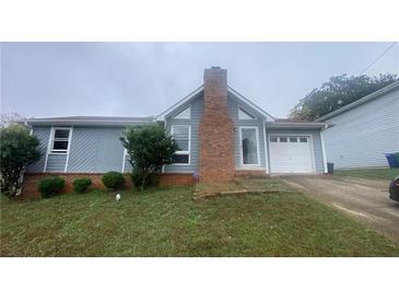 Gray house with brick chimney and attached garage at 2073 Marbut Ln, Lithonia, GA 30058