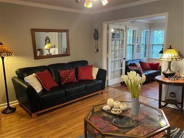 Living room with black leather sofa and sunroom access at 98 De Arc Nw, Atlanta, GA 30327