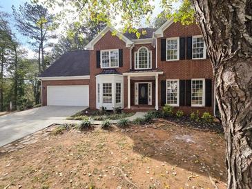 Brick two-story house with a large front yard and landscaping at 2654 Calumet Farm Ln, Snellville, GA 30039