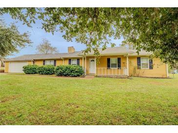 Ranch style home with attached garage and landscaped yard at 1187 Dixie Rd, Covington, GA 30014