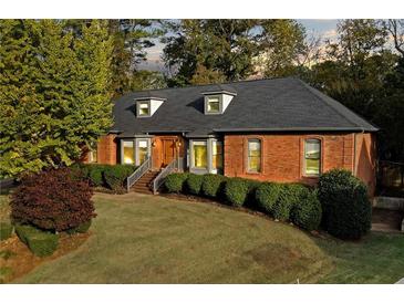Brick home with gray roof, landscaping, and a walkway leading to the entrance at 2545 Winthrope Way, Lawrenceville, GA 30044