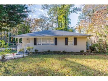 Ranch style home with a well-manicured lawn and mature trees at 2301 Delowe Dr, Atlanta, GA 30344