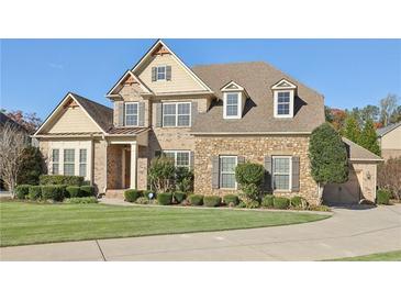Two-story brick home with stone accents, landscaped lawn, and a paved driveway at 2420 Bronze Ct, Cumming, GA 30041
