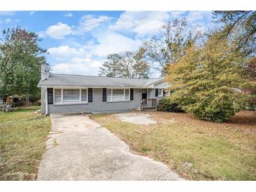 Ranch style home with gray exterior, landscaping, and a long driveway at 4257 Midway Rd, Douglasville, GA 30134