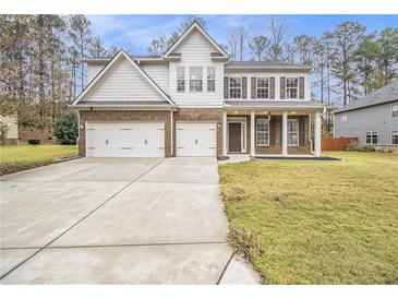 Two story house with a three-car garage and landscaped yard at 2166 Leatherstone Dr, Powder Springs, GA 30127